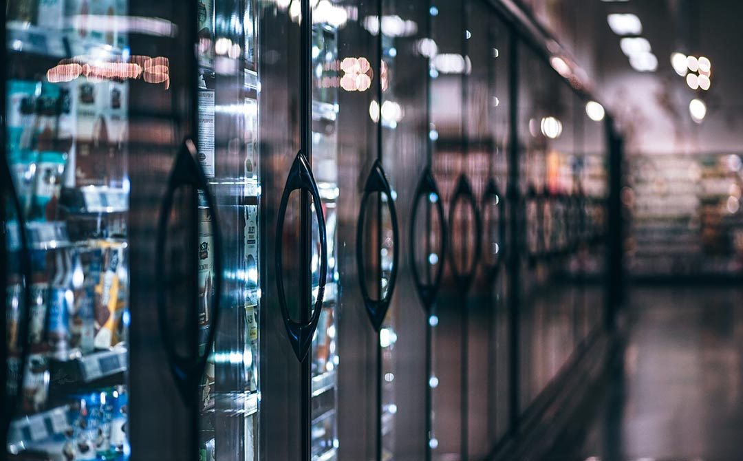 Row of commercial refrigeration units in a stainless steel kitchen