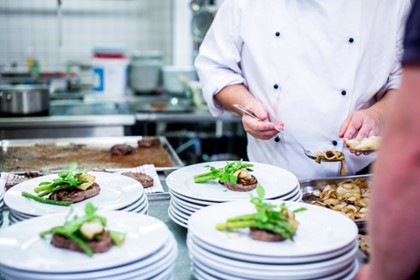 Chef plating dishes in a commercial restaurant kitchen