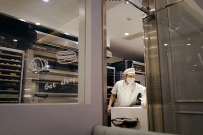 Commercial kitchen staff member near a reach-in refrigerator