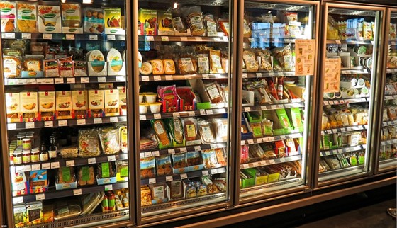 Grocery store refrigerated display case stocked with packaged food