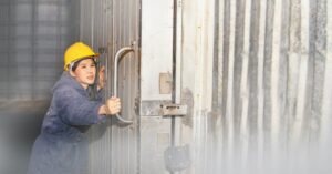 Technician inspecting the door handle of a commercial walk-in cooler for gasket wear